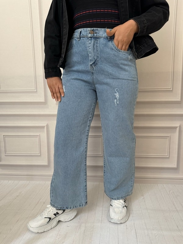 شلوار زنانه جین بگ سنگشور شده رنگ آبی روشن، نمای تمام قد، فاق بلند، مدل گشاد، دارای دکمه و زیپ، پشت کمر کشدار (سایز ۴۰ تا ۵۲)