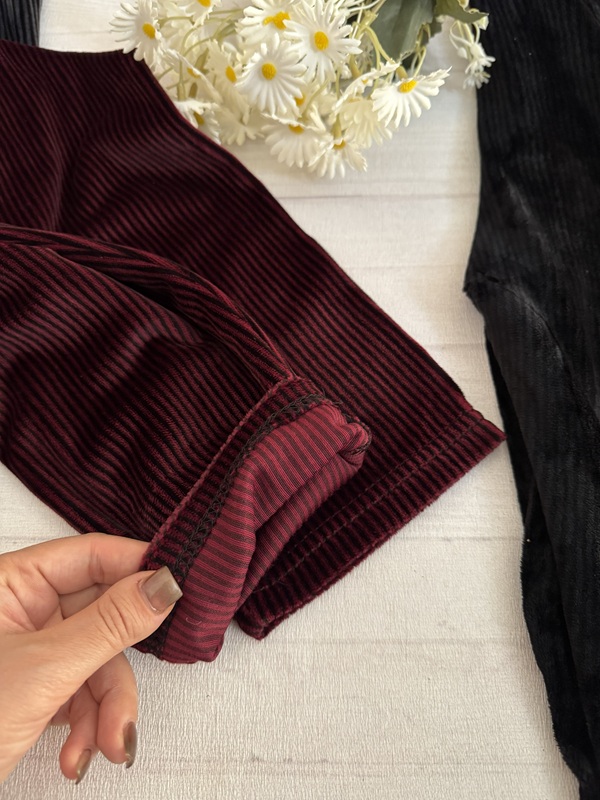 نمای نزدیک از بافت داخلی شلوار جذب زنانه مخمل کبریتی رنگ زرشکی (شرابی)، نشاندهنده لایه داخلی نرم و ضخیم پارچه، مناسب فصول سرد سال