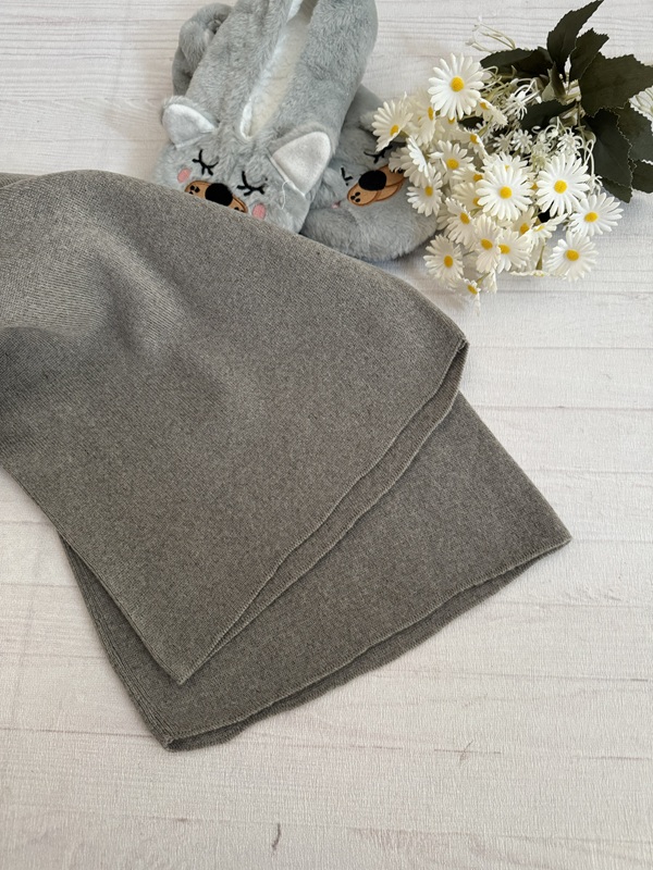 نمای نزدیک بافت شلوار زنانه بافت بگ آیریس ساده رنگ خاکی ، نشاندهنده بافت کشباف نرم و بدون طرح پارچه با کیفیت بالا