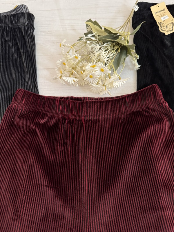 نمای نزدیک از جزئیات کمر تمام کش شلوار جذب زنانه مخمل کبریتی رنگ زرشکی (شرابی)، نشاندهنده بافت کبریتی نرم و خاصیت کشسانی بالا در قسمت کمر