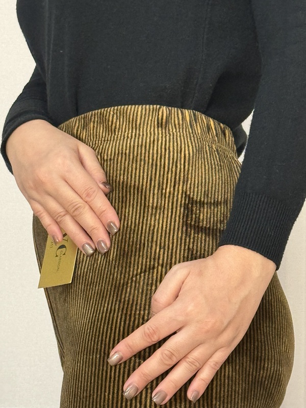نمای نزدیک از جزئیات کمر تمام کش شلوار جذب زنانه مخمل کبریتی رنگ زیتونی (سبز تیره)، نشاندهنده بافت کبریتی نرم و خاصیت کشسانی بالا در قسمت کمر