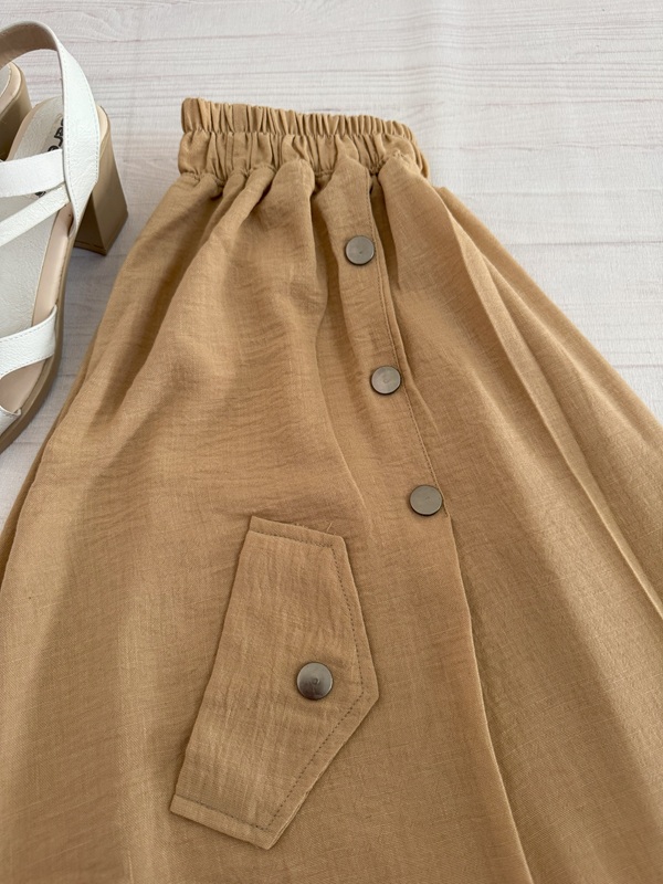 نمای جیب تزئینی از بغل بههمراه بخشی از کمر دامن – رنگ کرم – روی زمین