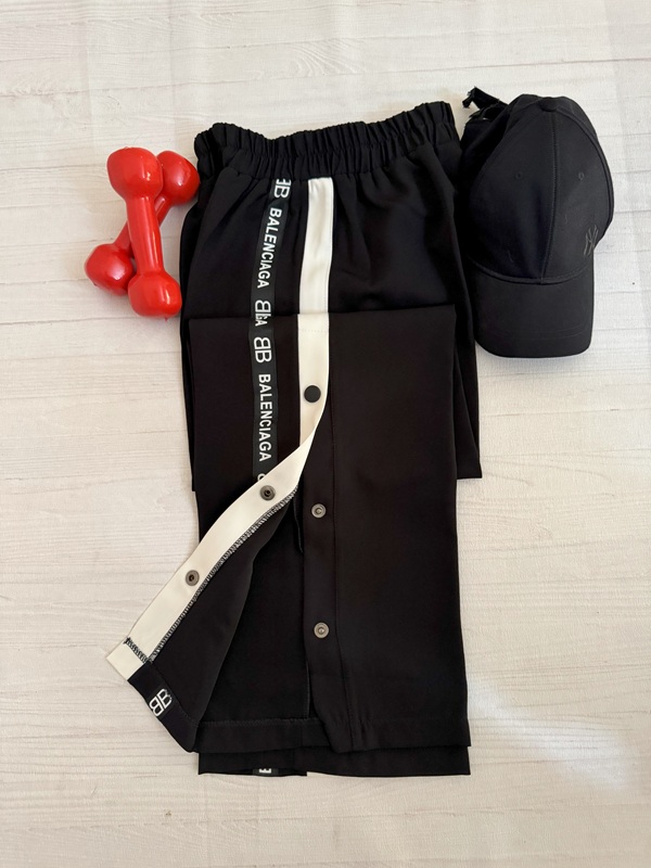 نمای کامل شلوار بالنسیاگا مشکی روی زمین با دکمههای باز در کنار پاچه