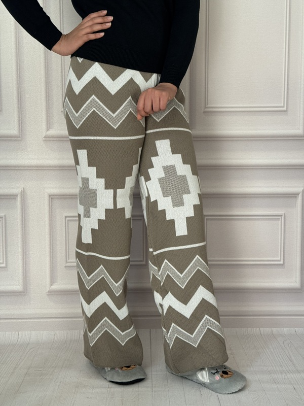 شلوار بافت طرح دار آیریس رنگ زیتونی تیره، مدل بگ، جنس کشباف نرم، با کمر تمام کش و طرح هندسی سفید و زیتونی