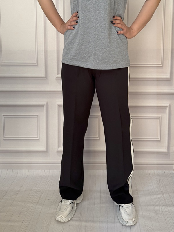 نمای جلوی شلوار ورزشی زیپ‌دار مشکی در تن مانکن با کمر کشی راحت و پارچه مازراتی