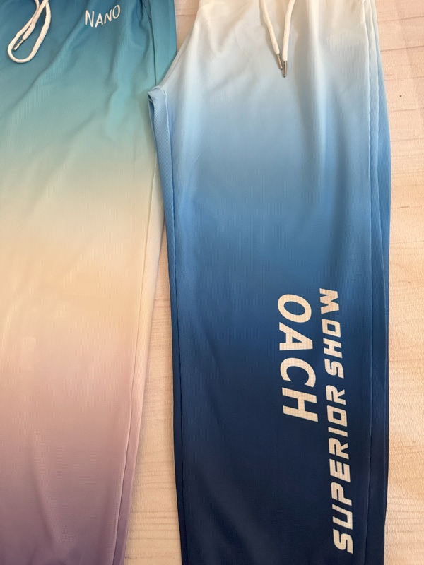 نمای حروف انگلیسی چاپشده روی ران شلوار زنانه آبرنگی آبی آسمانی روی زمین