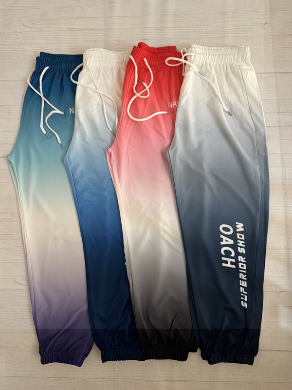 نمای کامل چهار شلوار زنانه آبرنگی (آبی آسمانی، سبز یاسی، قرمز و طوسی) پهنشده روی زمین