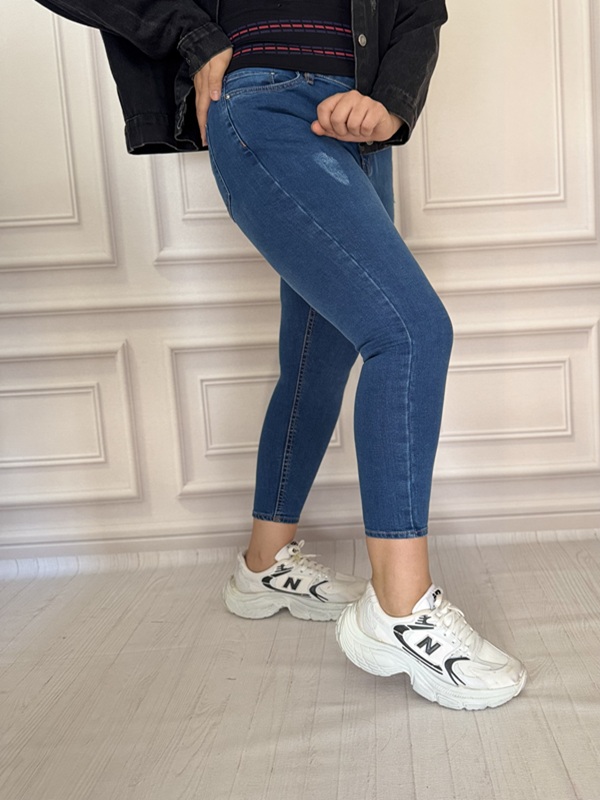 شلوار جین زنانه جذب آبی در نمای نیم‌رخ و قد ۹۰