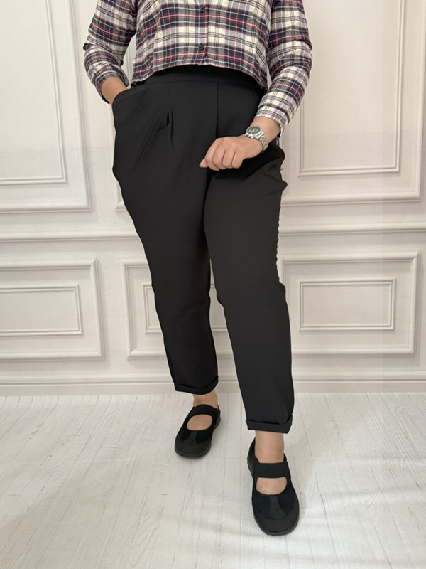 شلوار زنانه مشکی از جنس مازراتی با طراحی پاکتی و قد ۱۰۰، نمای جلو در تن مانکن