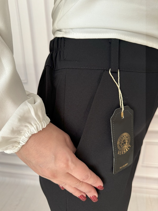 شلوار زنانه مشکی مازراتی مدل چاکدار، نمای جلو در حالت دست در جیب