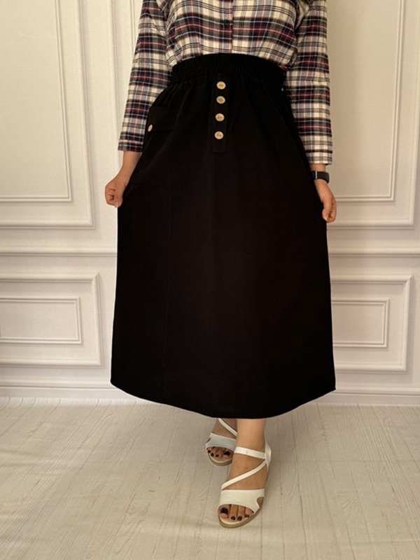 نمای جلوی دامن زنانه لینن مشکی با طراحی دکمه‌دار و کمر کشی در تن مانکن