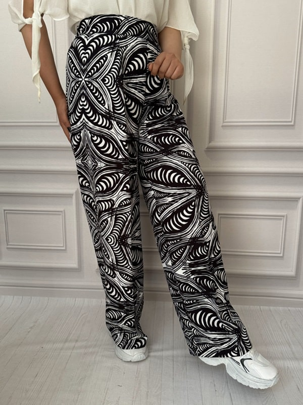 شلوار پارچهای بگ زنانه با طرح مارپیچی و متقارن سیاه و سفید، نمای بغل در تن مانکن