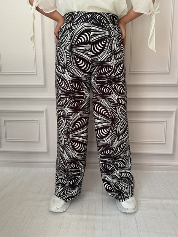 شلوار پارچهای بگ زنانه با طرح مارپیچی و متقارن سیاه و سفید، نمای جلو در تن مانکن