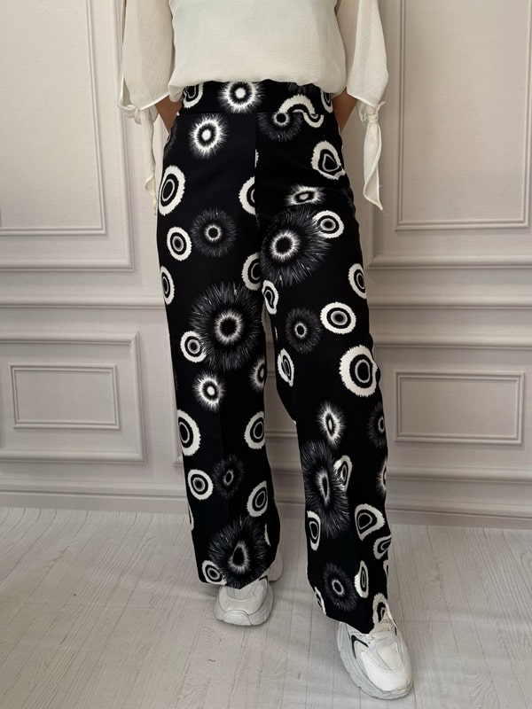 شلوار پارچهای بگ زنانه با طرح دایرهای روشن روی زمینه تیره، نمای جلو در تن مانکن