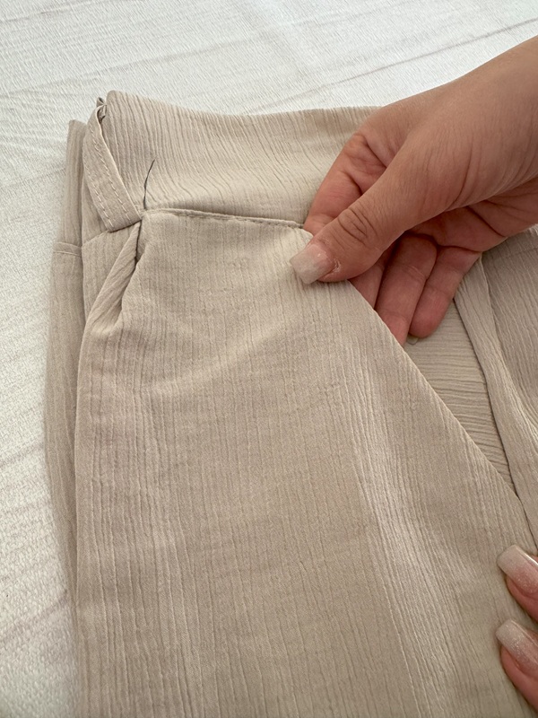 شلوار زنانه پارچهای کریستالی کرم، نمای جیب روی زمین