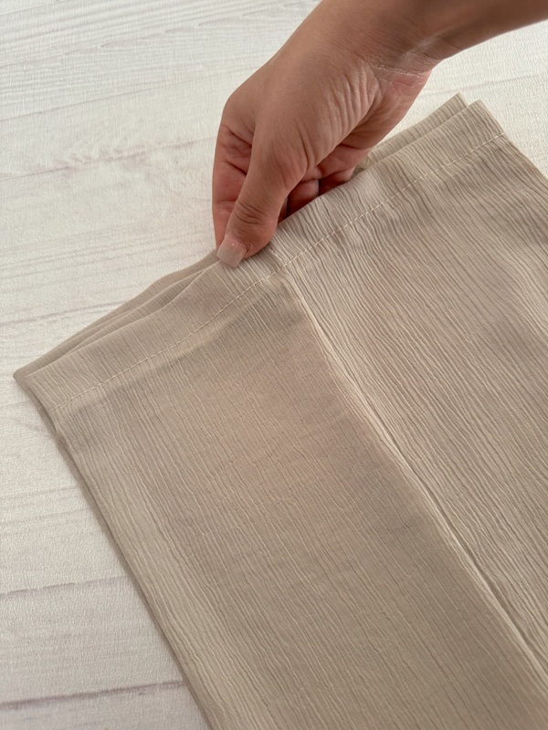 شلوار زنانه پارچهای کریستالی کرم، نمای پاچههای راسته روی زمین