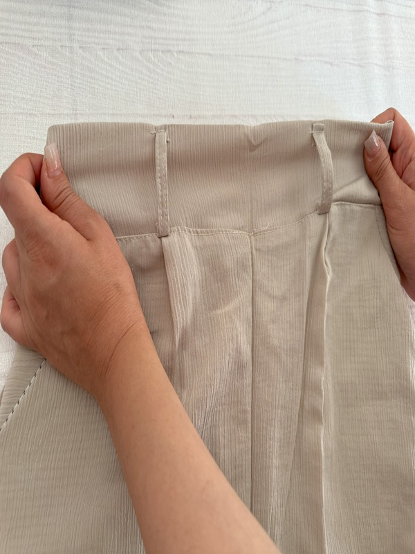 شلوار زنانه پارچهای کریستالی کرم، نمای جلو کمر ساده روی زمین