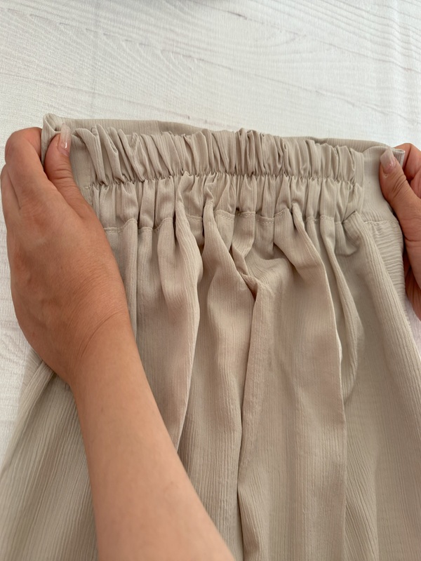 شلوار زنانه پارچهای کریستالی کرم، نمای پشت کمر کشی روی زمین