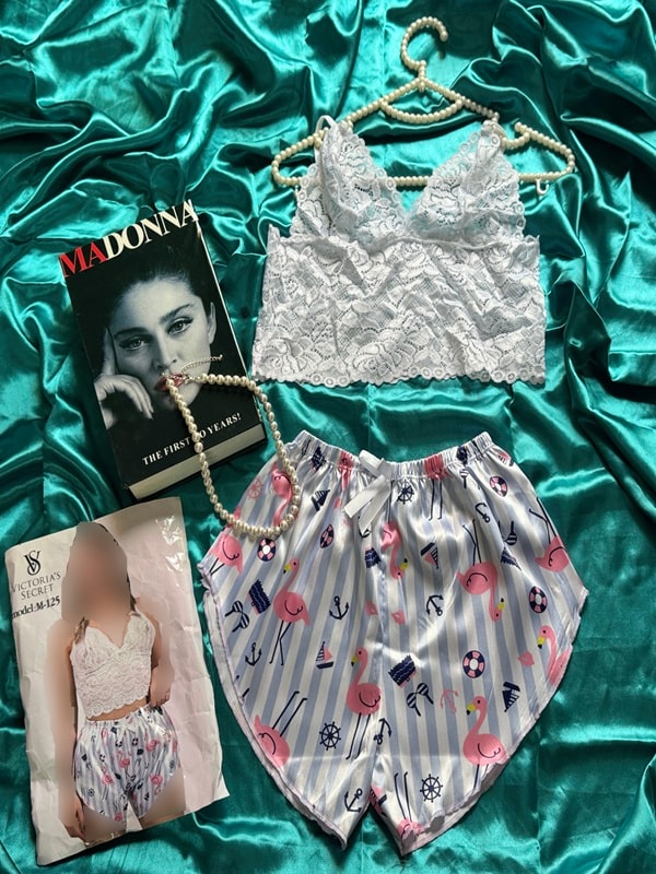 نمای کامل ست لباس خواب فانتزی شامل نیم‌تنه گیپوری سفید و شورتک ساتن براق طرحدار با طرح فلامینگو و دریایی، چیدمان شده روی زمینه ساتن سبز با بسته‌بندی و دکور مجله