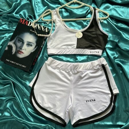 نمای ست ورزشی زنانه شامل نیم‌تنه و شورتک سفید مشکی با طرح اسپرت برند ELENA روی زمینه ساتن سبز