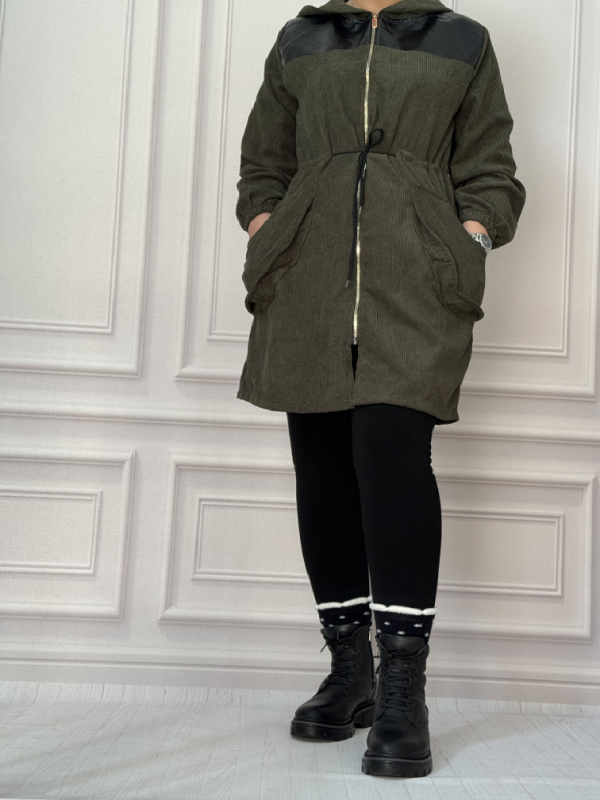 مانتو زنانه جنس مخمل کبریتی ریزباف رنگ سبز زیتونی، دارای ترکیب چرم مشکی در سرشانه، مدل کلاهدار زیپی با کمر گت‌دار و جیب‌های کاربردی، مناسب استایل اسپرت و دانشجویی